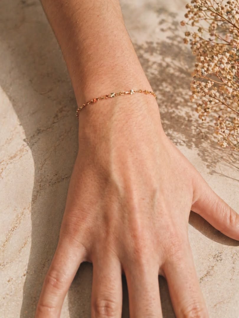 Delicate 14k gold-filled satellite chain welded bracelet resting on a hand at golden hour — Athens, GA