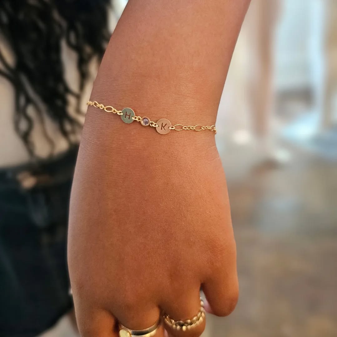 14k gold-filled permanent bracelet with H and K initial discs and birthstone bezel — custom Athens, GA welded jewelry